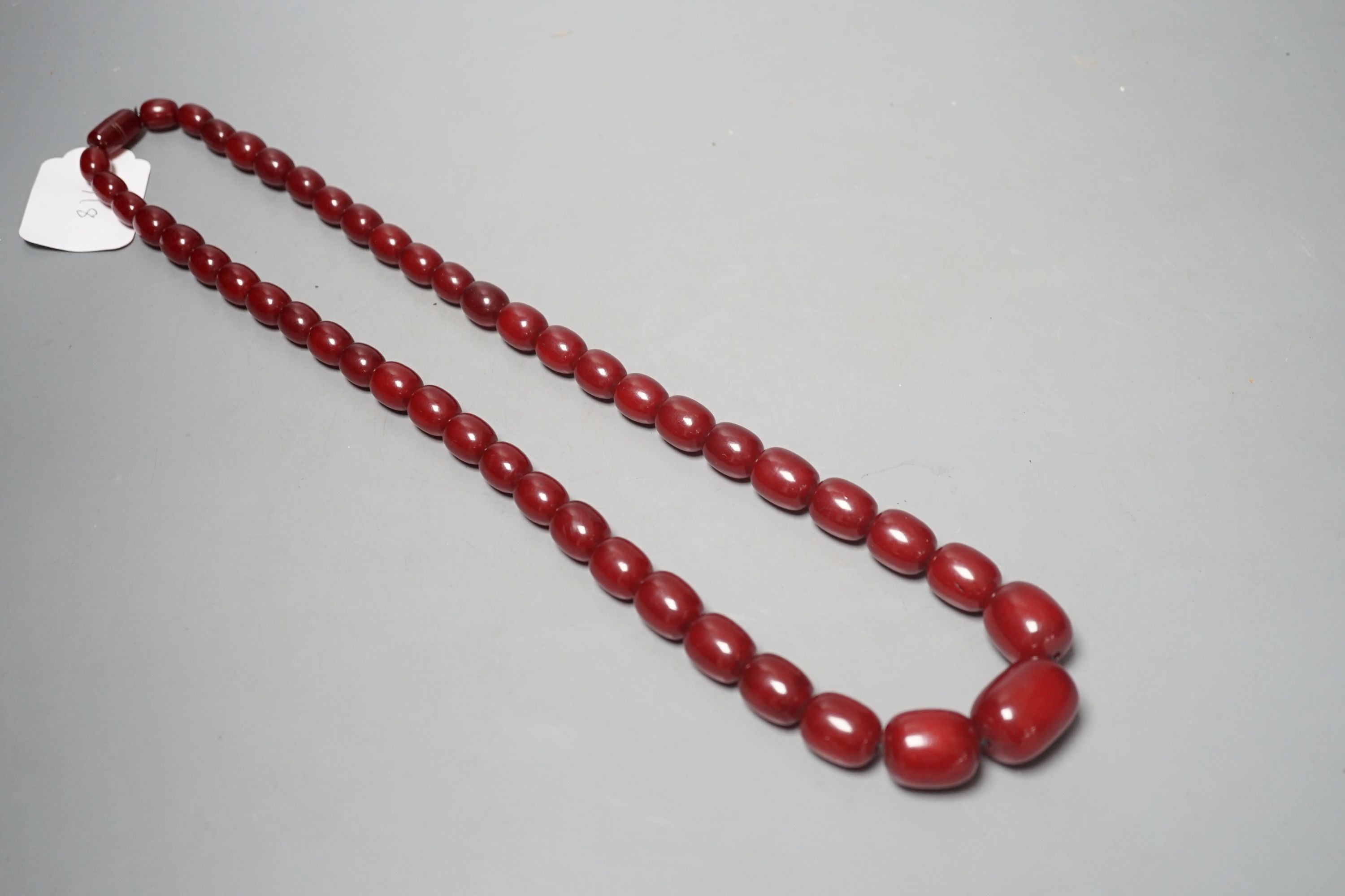 A single strand graduated oval simulated cherry amber bead necklace, 78cm, gross weight 121 grams.